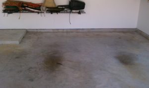 Bare, worn concrete garage floor before epoxy coating