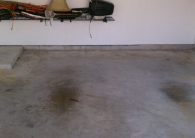 Bare, worn concrete garage floor before epoxy coating